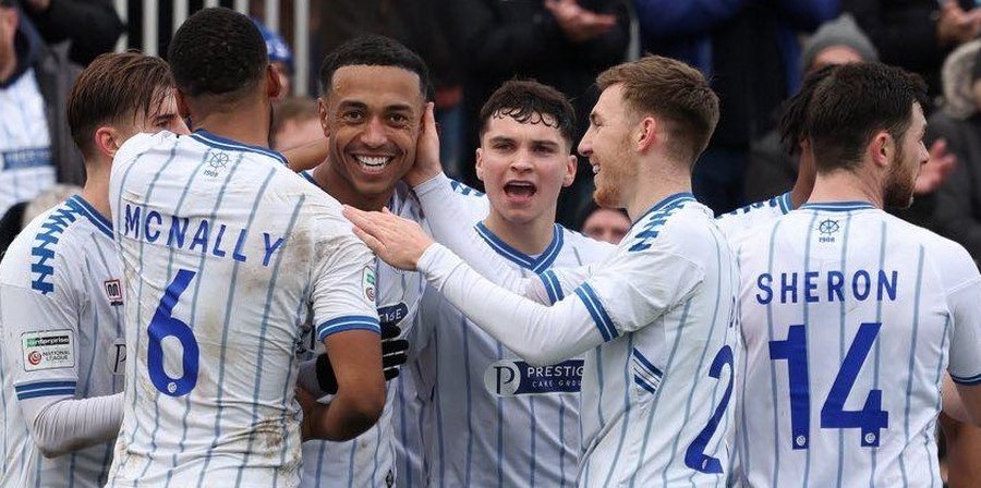 Hartlepool United players celebrating together as a team in front of the fans