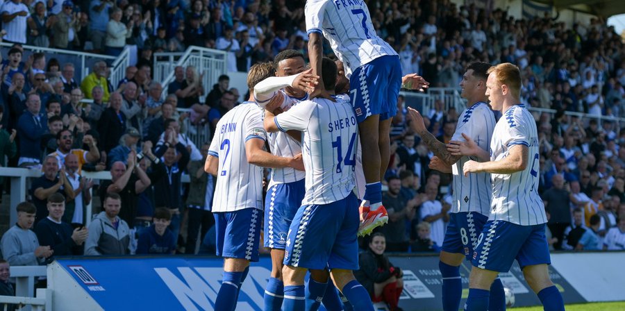 Hartlepool United players celebrating together as a team in front of the fans